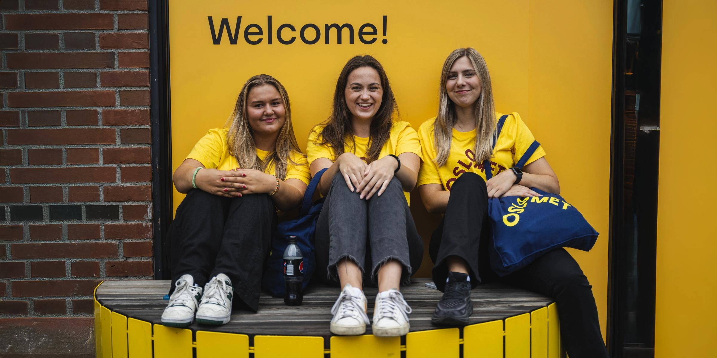 Tre kvinner ser mot kamera og smiler.